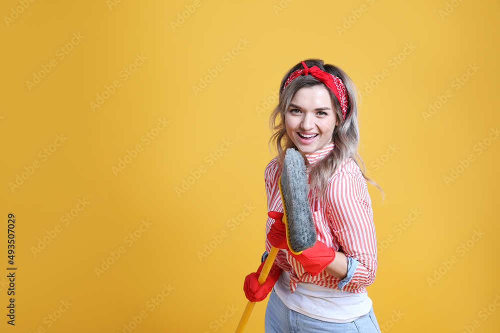 Beautiful young woman with floor brush singing on orange background. Space for text Beautiful young woman with floor brush singing on orange background. Space for text
