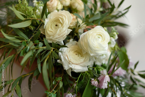 Wedding rustic bouquet in close-up. A beautiful luxurious bouquet consisting of ranunculus and cream-colored roses. Wedding day. Creation of a family  marriage ceremony of a couple.