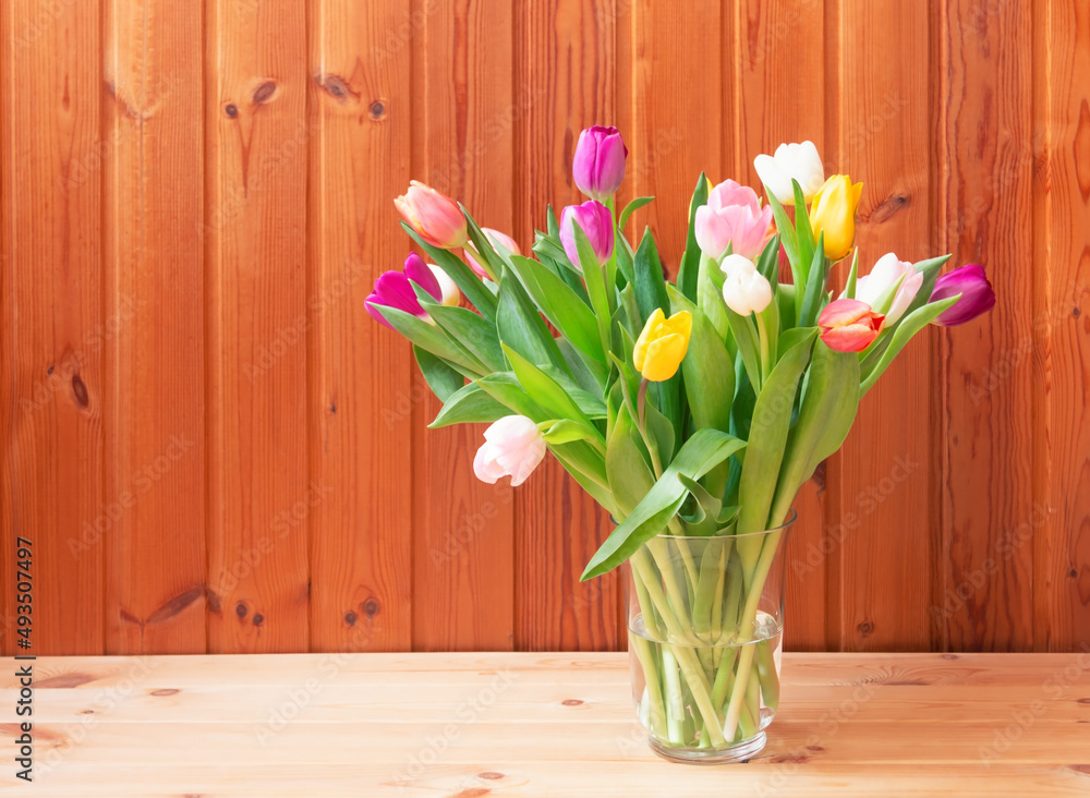 Bouquet of fresh colorful tulips in vase on wooden table. Bouquet of fresh colorful tulips in vase on wooden table.
