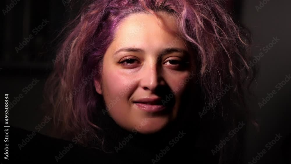 woman with pink hair looking into room at home with dark background. close up woman with pink hair looking into room at home with dark background. close up