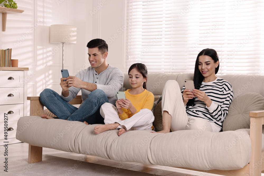 Internet addiction. Family with gadgets on sofa in living room Internet addiction. Family with gadgets on sofa in living room