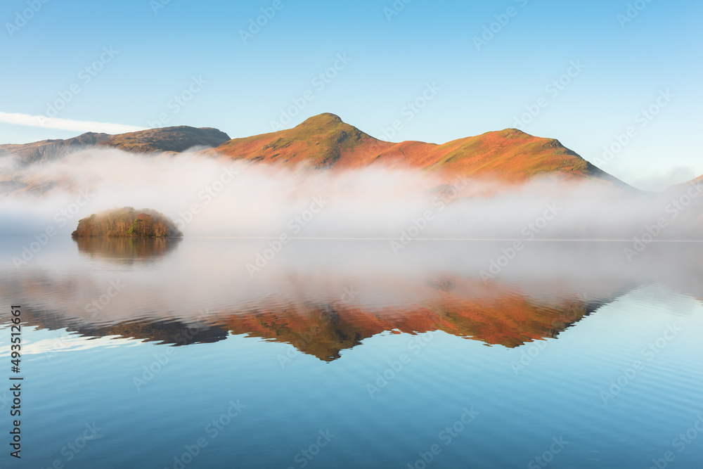 Calming reflections on a sunny morning at Derwentwater in the Lake District, UK.