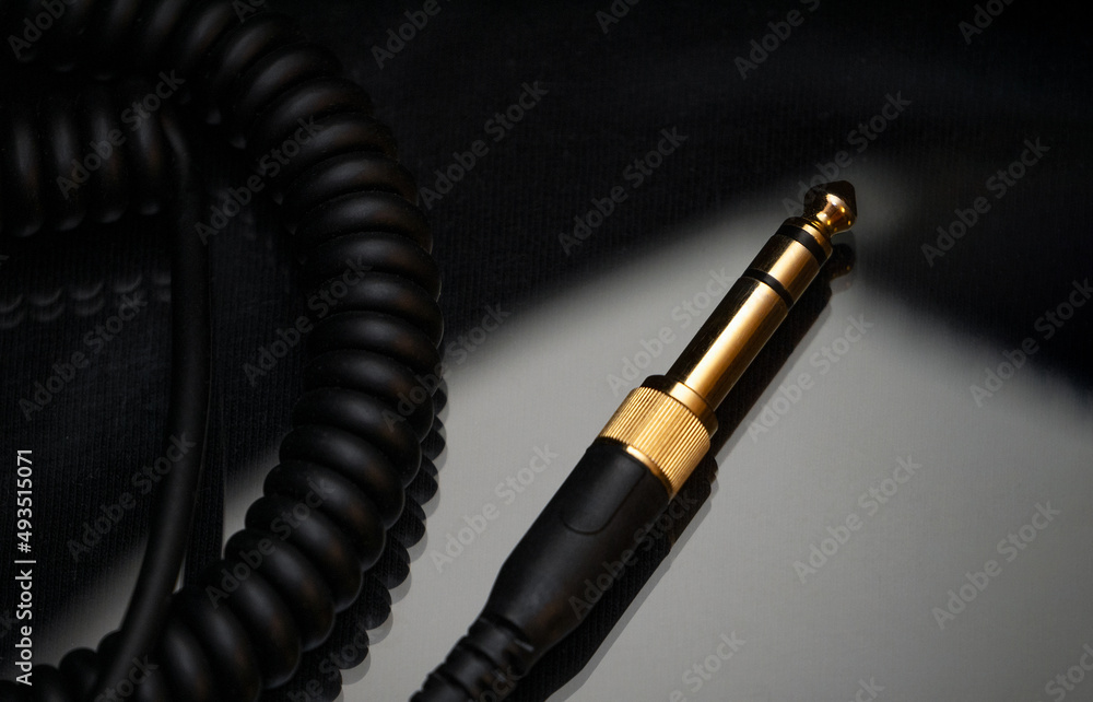 Naklejka premium Gold-plated TRS connector for the analog audio signal are placed against a black background. Professional jack connector for sound equipment. Audiophile technologies concept.