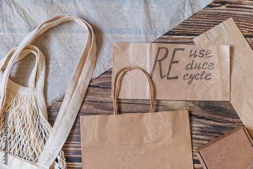 Reduce, reuse, recycle, refill. Eco friendly shopping bags on wooden background. Zero waste sustainable lifestyle. Plastic free concept.