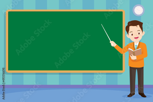 Young male teacher hold a book at blackboard in classroom
