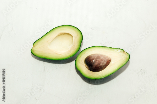 Green ripe avocado on a light background, healthy food concept.