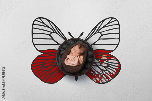 Tiny baby portrait with wings in color of national flag. Newborn photography concept. Poland