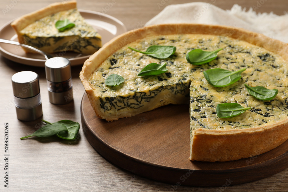 Delicious homemade spinach pie and spices on wooden table Delicious homemade spinach pie and spices on wooden table
