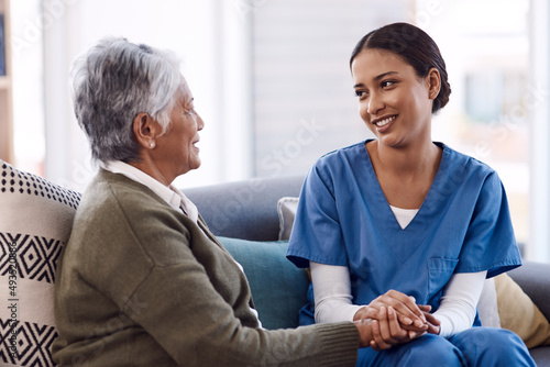 Im here to lend my support whenever you need. Shot of a young nurse chatting to a senior woman in a retirement home. photo