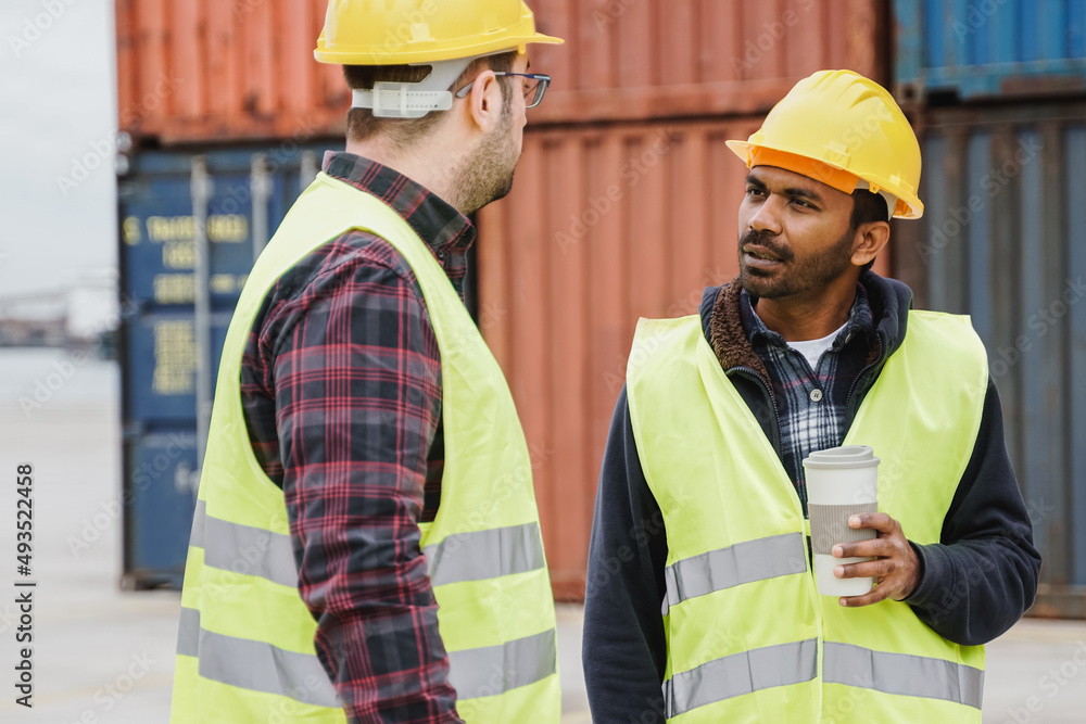Multiethnic industrial operators working inside international containers port terminal - Freight logistics operations - Focus on Indian worker man Multiethnic industrial operators working inside international containers port terminal - Freight logistics operations - Focus on Indian worker man