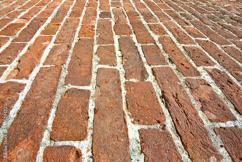Old paving made with bricks blocks in an italian pedestrian zone