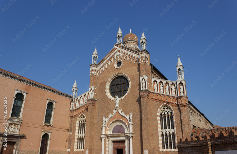 Beautiful red brick Italian church against the blue sky. Detail of the Madonna dell'Orto church, Venice, Italy.