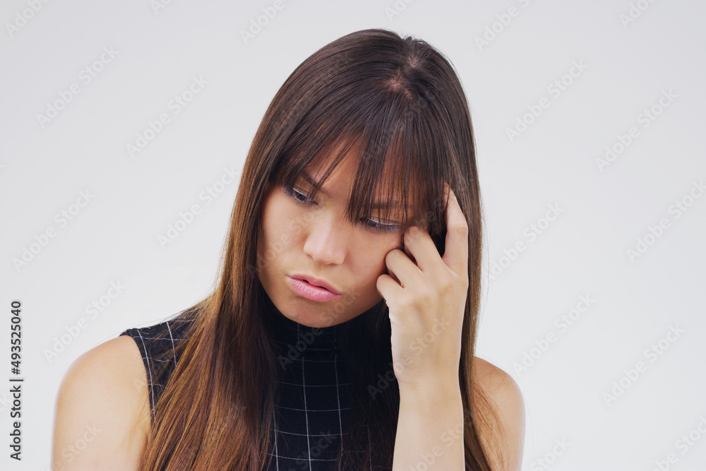 Sometimes its just hard to decide. Studio shot of a young woman looking thoughtful against a gray background. Sometimes its just hard to decide. Studio shot of a young woman looking thoughtful against a gray background.
