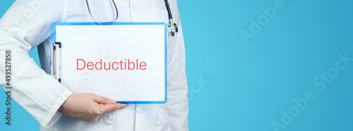 Deductible. Doctor with stethoscope holds blue clipboard. Text is written on document. photo