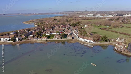 Aerial footage over Langstone Harbour towards a row of traditional English cottages in an area to the south of Havant on the waterfront of the harbour.