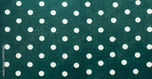 green fabric with white polka dots background
