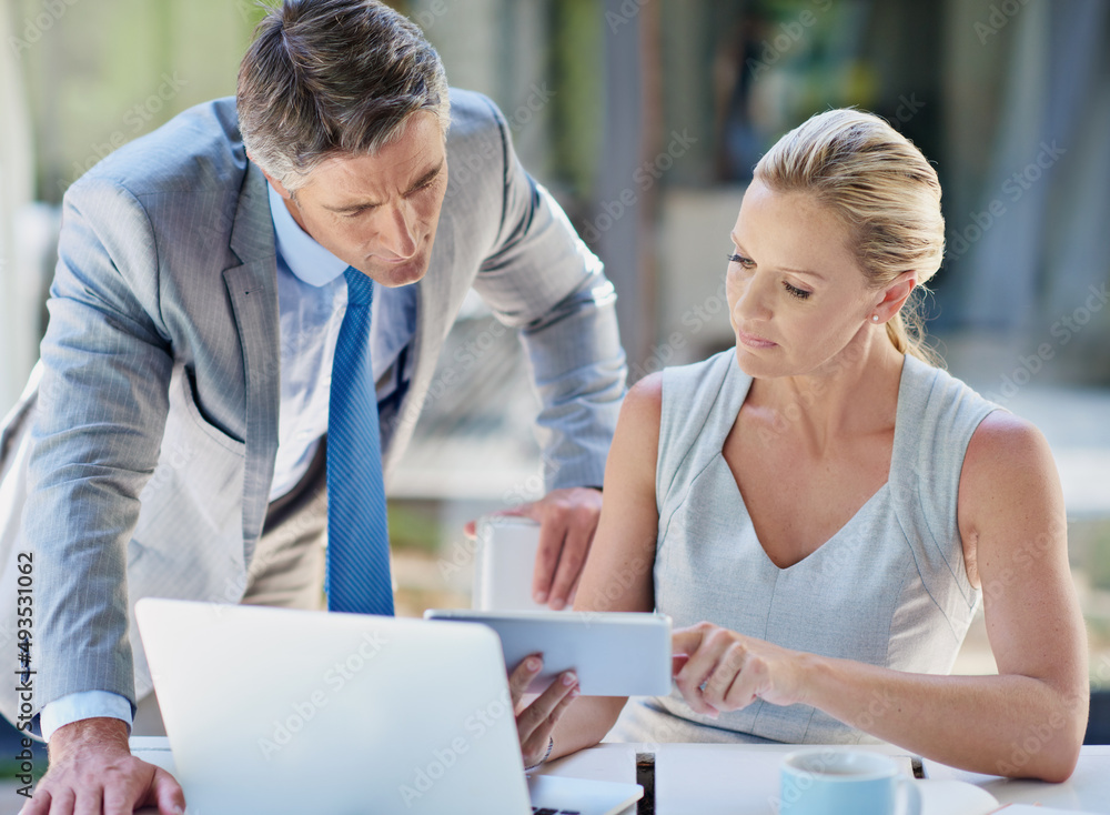 Masters of their own success. Shot of two mature businesspeople talking together of a tablet and laptop. Masters of their own success. Shot of two mature businesspeople talking together of a tablet and laptop.