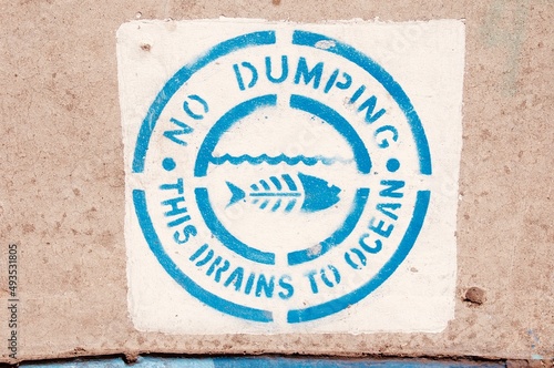 Stenciled sign warning no dumping in ocean drain