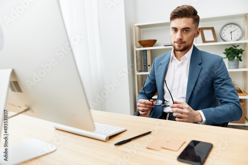 a man in a suit sitting at the computer work boss Gray background
