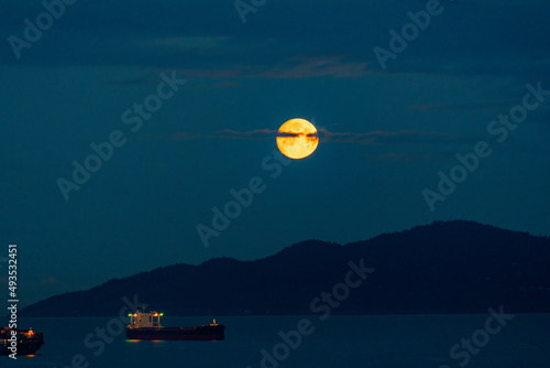 the orange full moon set in the earlier morning