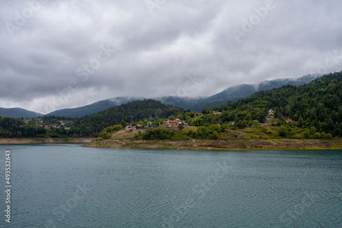 Tranquil view of remote mountain village with lake in misty summer morning. Nature outdoors travel destination, National park Tara, Zaovine lake, Serbia