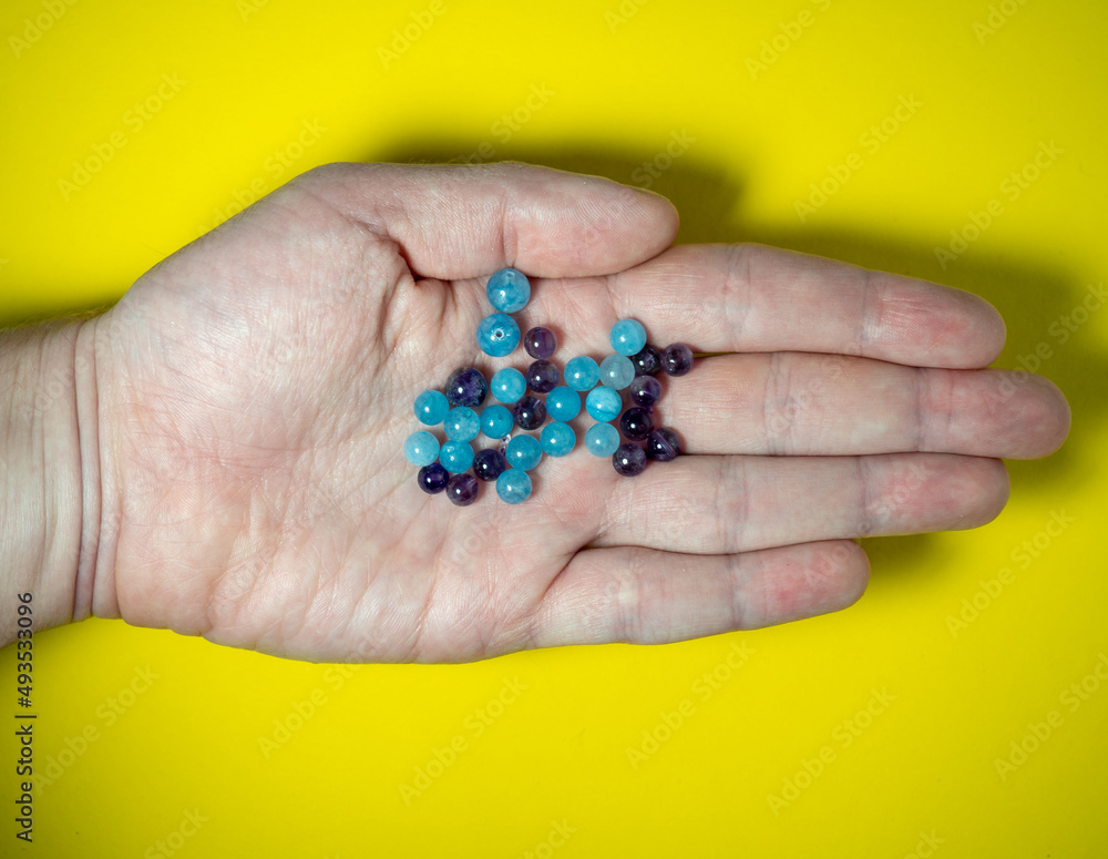 Blue beads on the palm. Chalcedony and amethyst . Bijouterie. Stones in the workshop Blue beads on the palm. Chalcedony and amethyst . Bijouterie. Stones in the workshop