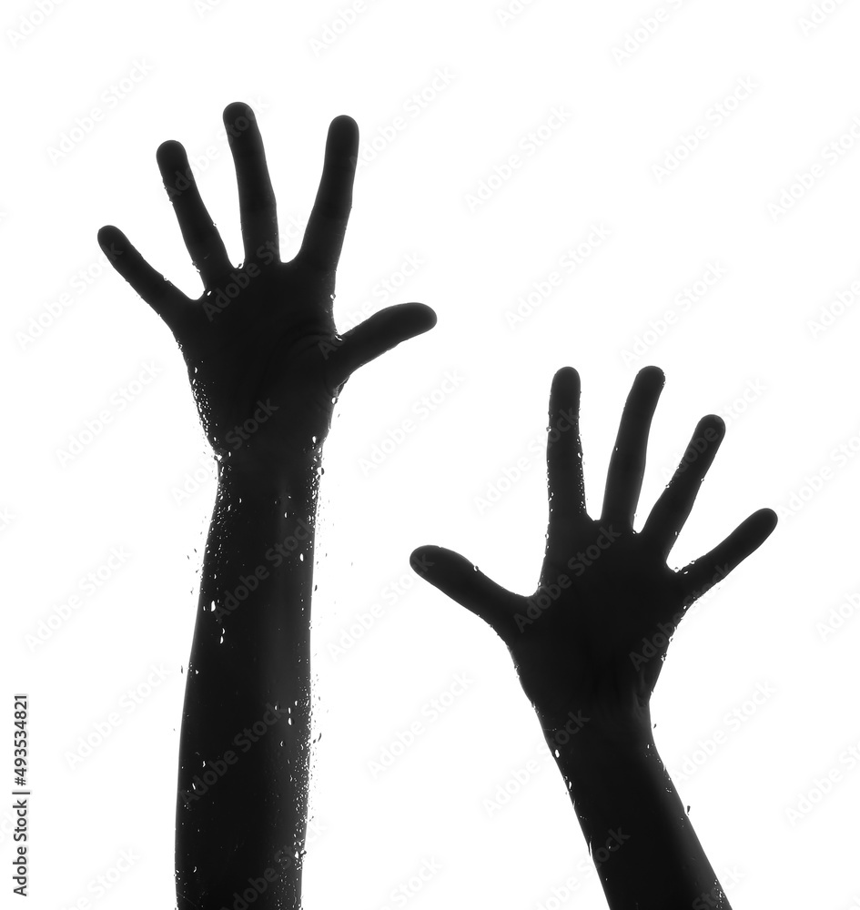 Silhouette of female hands visible through glass with water drops on white background Silhouette of female hands visible through glass with water drops on white background