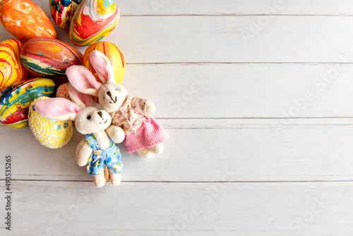 Easter decorated background, eggs and cloth bunny top view.
