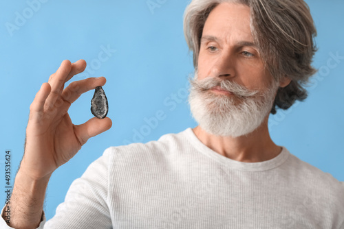 Mature man with gemstone on...