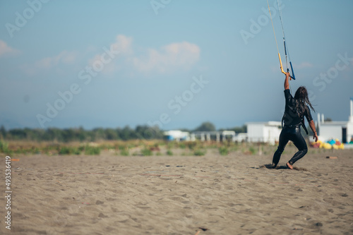 Woman using control bar to lift her kite up for kitesurfing