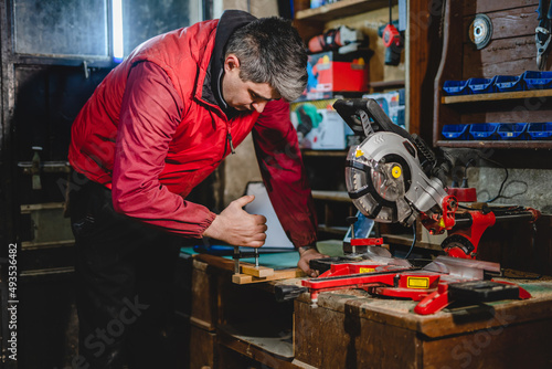 One man caucasian adult male working by the circular saw and work tools at garage workshop real people copy space hobby and craft concept