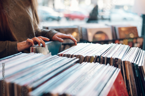 Woman hands choosing vinyl record in music record shop photo