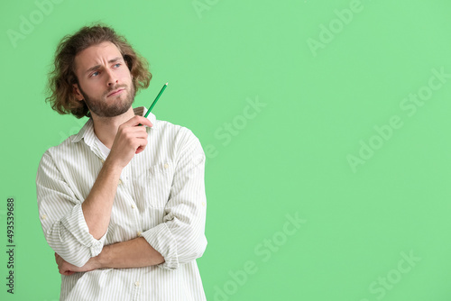 Handsome man with pencil on...