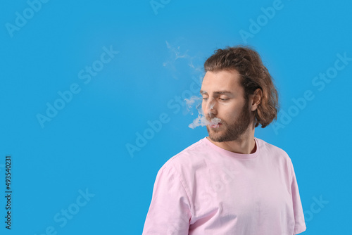 Fotografía Smoking young man on blue background