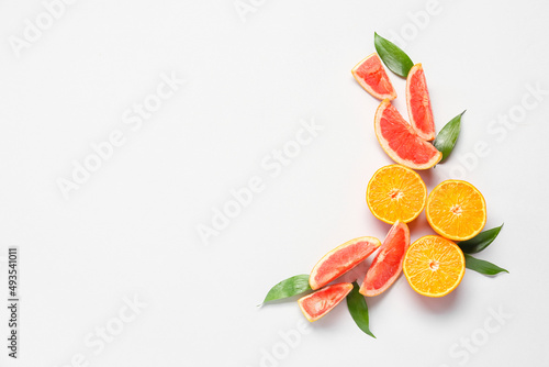 Fresh orange and grapefruit slices on light background