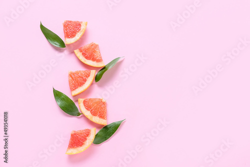 Fresh grapefruit slices on pink background