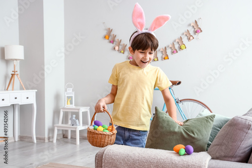 Canvastavla Cute little boy looking for hidden Easter eggs at home