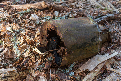 Old, rusty, broken, abandoned metal milk can.