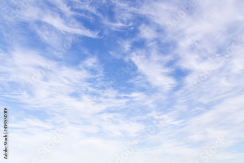 Beautiful epic soft gentle blue sky with many white cirrus and fluffy clouds, abstract background texture 