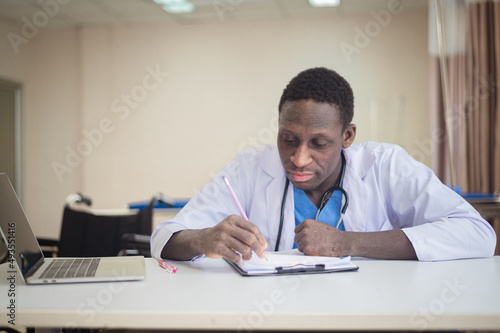 African American doctor using computer check patient data document