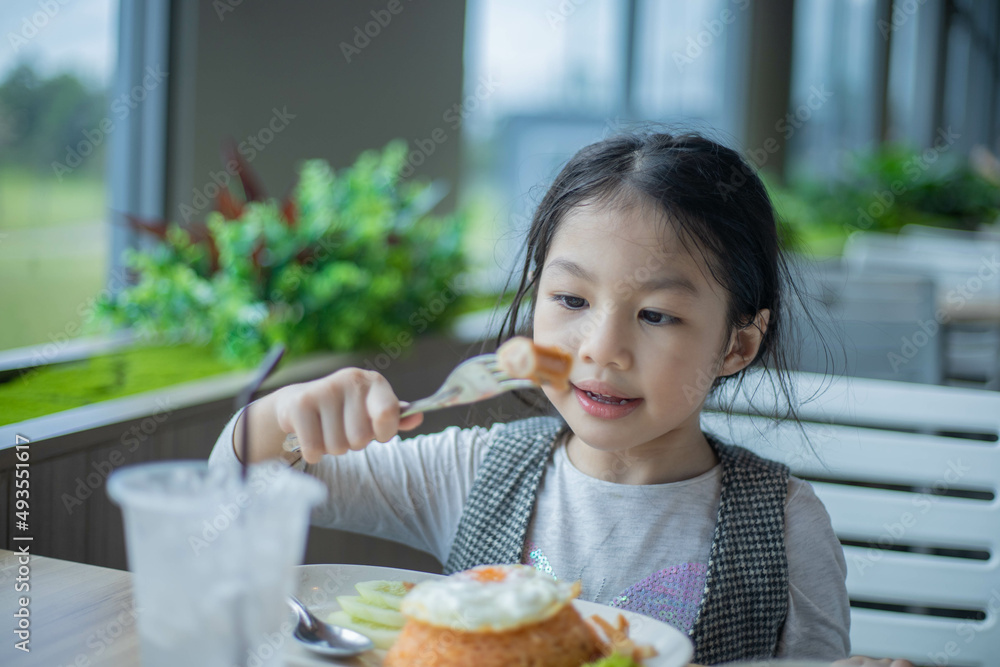 Asian girl enjoy eating food for breakfast or lunch in restaurant. Asian girl enjoy eating food for breakfast or lunch in restaurant.