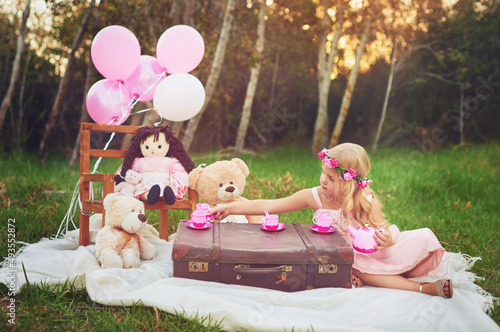 Tea time with my friends. Shot of an adorable little dressed as a princess having a teat party with her stuffed toys in the garden.