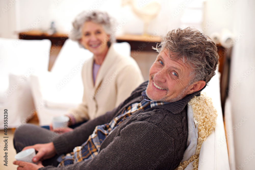 Obraz premium Home sweet home. Portrait of a loving senior couple sitting together in their lounge.