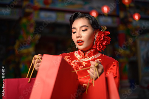 Asian pretty Chinese woman dress traditional cheongsam holding shopping bag