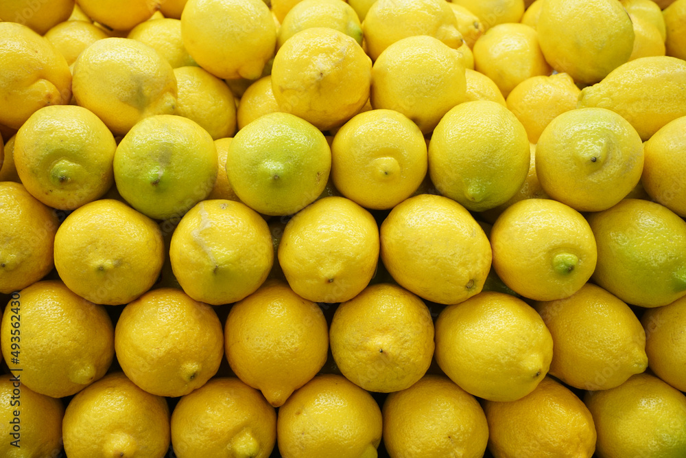 fresh yellow lemon arranged in pile as food background