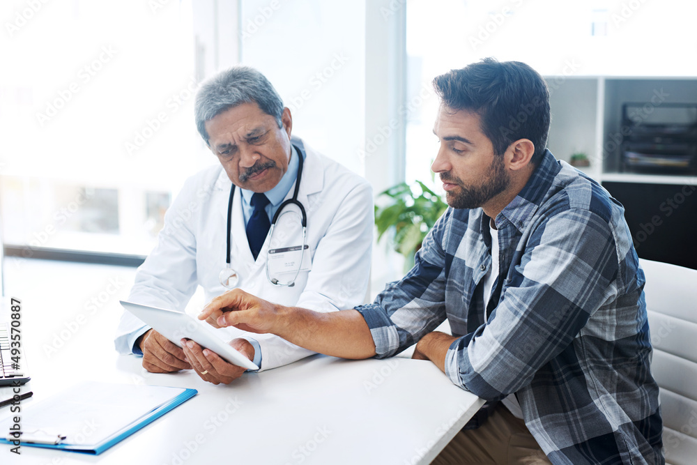 Fototapeta premium When last did you see a doctor. Shot of a mature male doctor and patient having a discussion in the doctors office before a checkup.