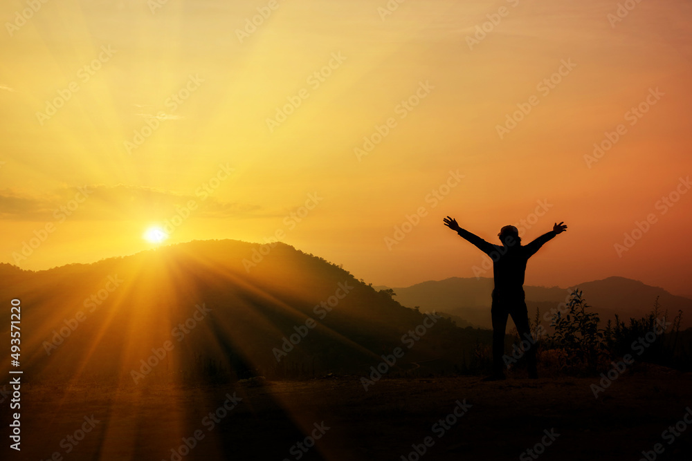 Man raising his arms to thank God on the mountain