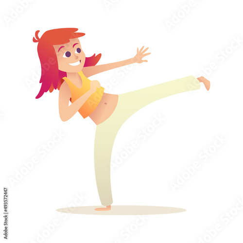 Child practices capoeira and kick. Girl with red hair has fun doing sports, stands in warlike pose.