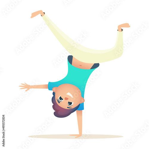 Child has fun and stands upside down on one arm. Boy goes in for sports, Brazilian capoeira