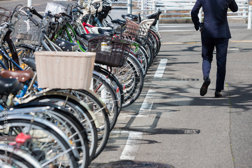 Obraz premium 日本の町の駐輪場の風景と歩くサラリーマンの姿
